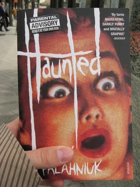 Person holding the book Haunted Person holding the book