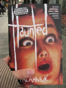 Person holding the book Haunted Person holding the book